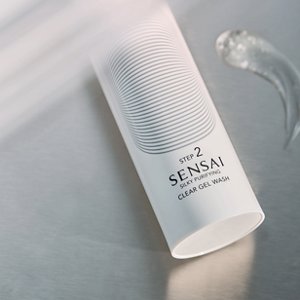 A close up of Silky Purifying Clear Gel Wash product on table next to texture